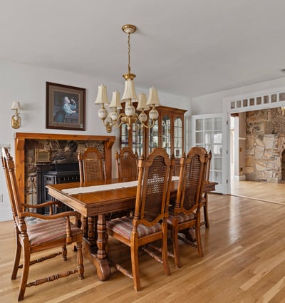 Spacious dining area features a classic table set, surrounded by natural light and detailed woodwork throughout.