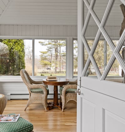 Inviting sunlit space featuring expansive windows and cozy seating, perfect for relaxation and gatherings.
