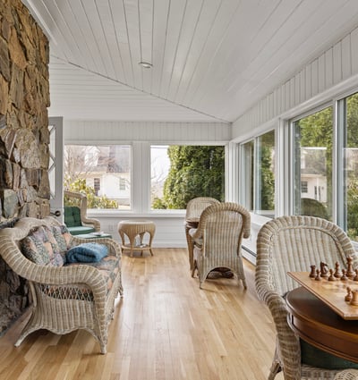 Bright, sunlit sunroom featuring expansive windows, natural stone accents, and inviting seating for relaxation or play.