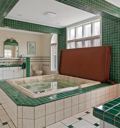 Spacious bathroom featuring unique tile work, a large jetted tub, and abundant natural light.