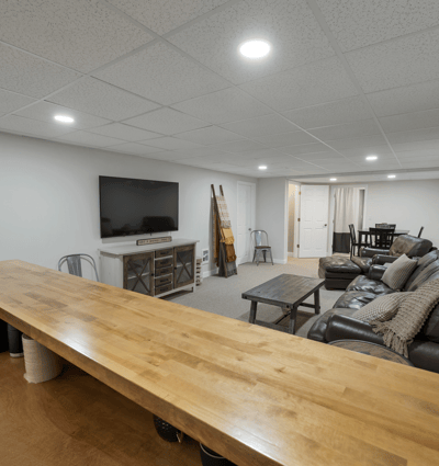 Spacious, versatile finished basement featuring a cozy lounge area and a convenient bar for entertaining.
