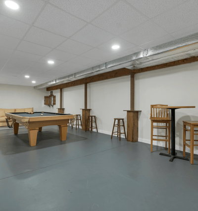 Spacious recreational area featuring a pool table, bar seating, and ample room for entertainment activities.