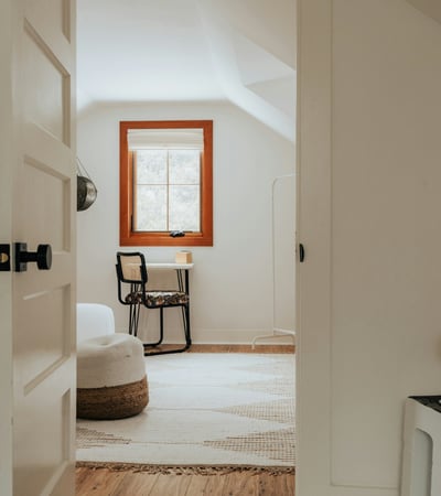Bright and open room featuring a cozy workspace and unique architectural details, perfect for relaxation or creativity.