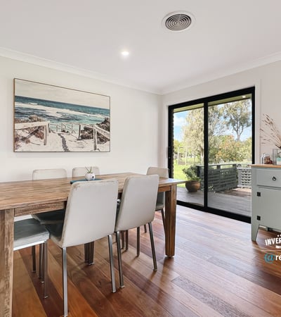 Bright dining area featuring large windows, showcasing views of the outdoors and modern design elements.
