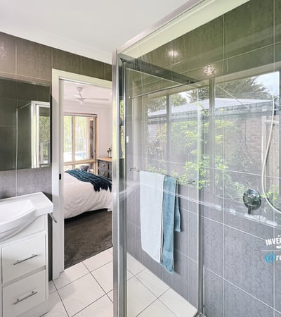 Modern bathroom featuring a spacious shower, sleek fixtures, and a seamless view of the landscaped garden.