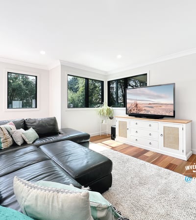 Spacious living area features large windows, modern furnishings, and ample natural light for a welcoming atmosphere.