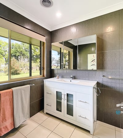 Bright and airy bathroom featuring modern fixtures, ample natural light, and scenic garden views.