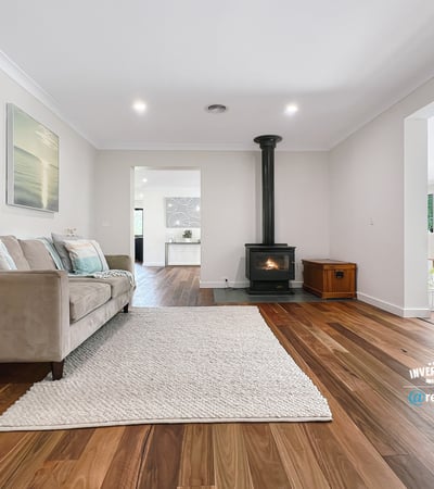Spacious living area featuring natural light, modern decor, and a cozy fireplace, perfect for gatherings.
