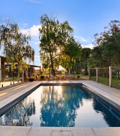 Discover this inviting outdoor space featuring a refreshing pool, surrounded by lush greenery and modern amenities.