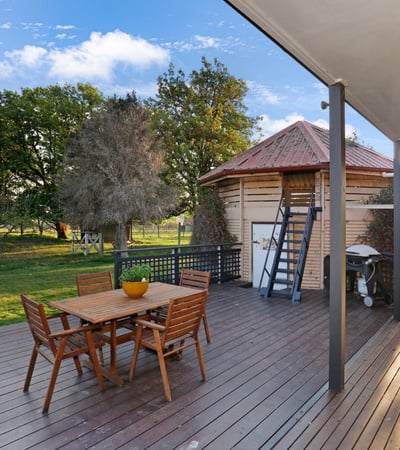 Spacious outdoor deck with direct access to lush greenery, ideal for entertaining and relaxation.