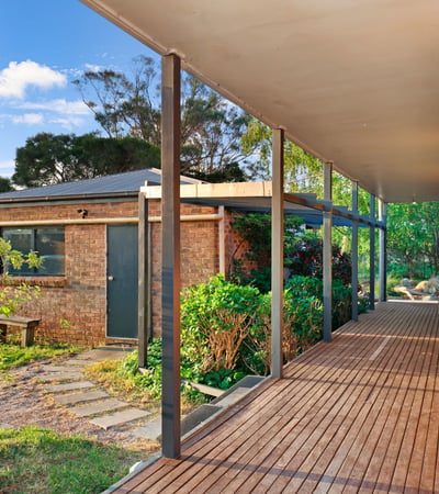 Spacious covered porch leads to a well-maintained garden, offering a welcoming entry to this unique property.