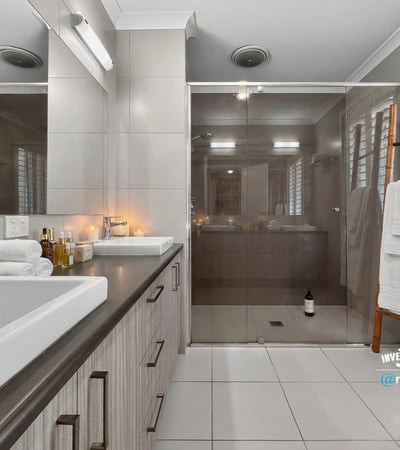 Modern bathroom featuring spacious shower, dual vanities, and clean lines, perfect for daily relaxation.