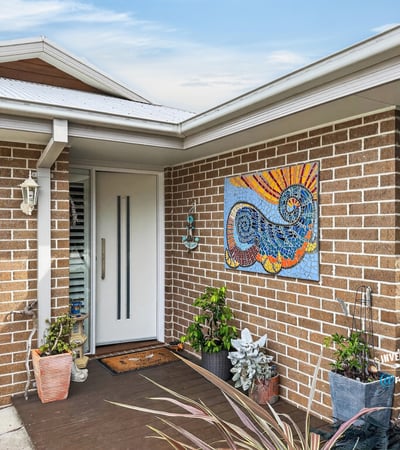 Welcoming entrance features vibrant artwork and lush greenery, offering a warm first impression to visitors.