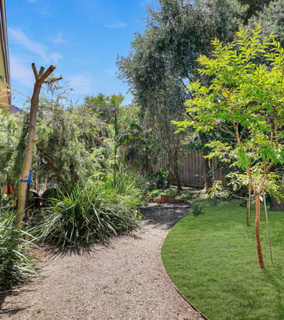 This property features a private garden oasis with lush plants and a peaceful outdoor seating area.