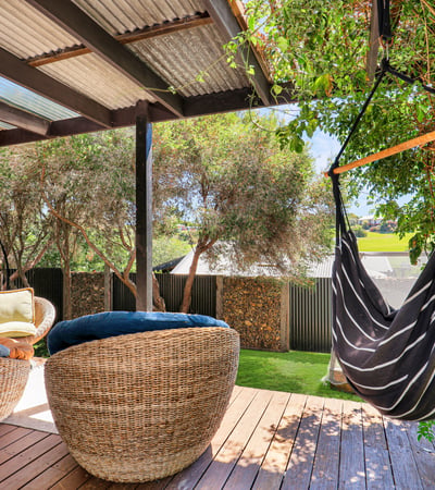 Inviting outdoor space with comfortable seating and a hammock, perfect for relaxation and entertaining.