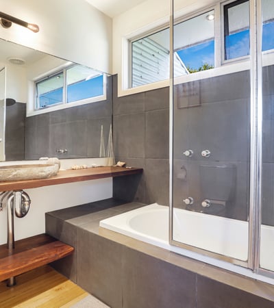 Modern bathroom featuring a sleek vanity, luxurious soaking tub, and large glass shower for ultimate comfort.
