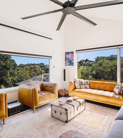 Bright and spacious living area featuring large windows, modern furnishings, and scenic views of nature.