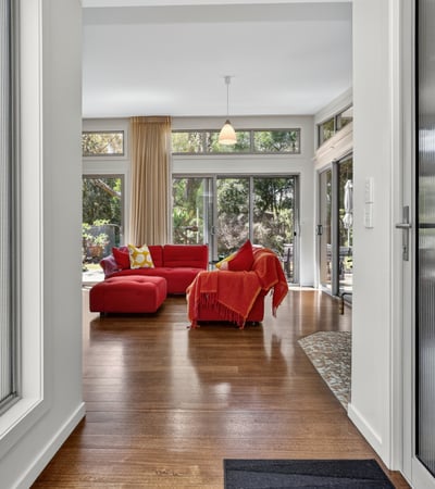 Bright and open living space features large windows and direct access to lush outdoor views.