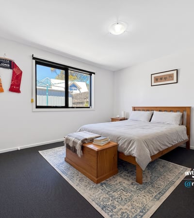 Spacious bedroom featuring ample natural light, modern furnishings, and a cozy atmosphere ideal for relaxation.