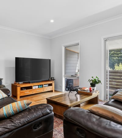 Discover a cozy living space featuring comfortable seating, a modern TV, and easy outdoor access.