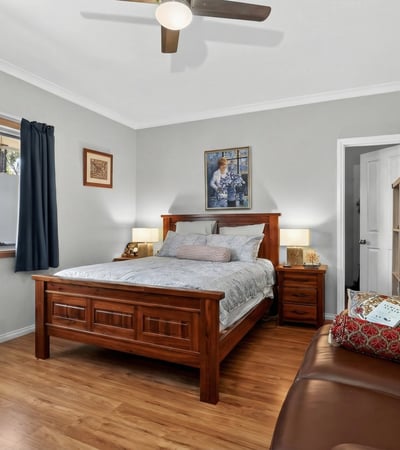 Bright and inviting bedroom featuring natural light, modern furnishings, and a cozy seating area for relaxation.