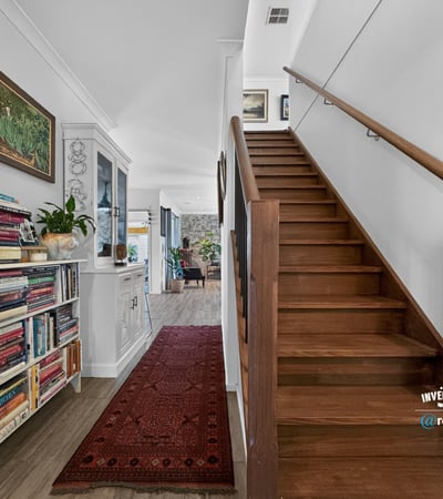 Spacious entryway featuring a wooden staircase, built-in shelving, and vibrant decor create a welcoming atmosphere.
