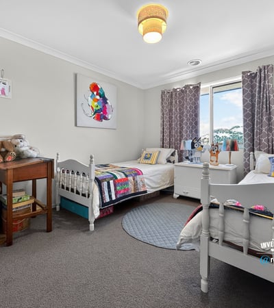 Bright and inviting bedroom featuring cozy beds, playful decor, and ample natural light. Perfect for creativity!