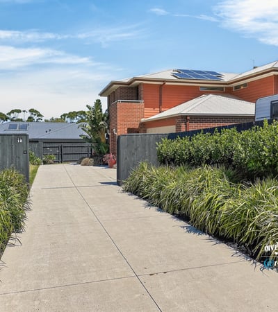 This property features a spacious driveway surrounded by well-maintained landscaping, leading to a modern home.