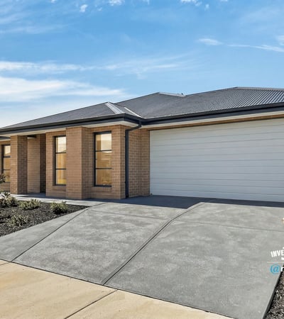 Modern home featuring a spacious driveway and large windows, perfect for natural light and convenience.
