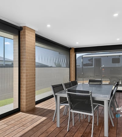 Spacious outdoor dining area featuring weather-resistant screens and ample room for entertaining guests.