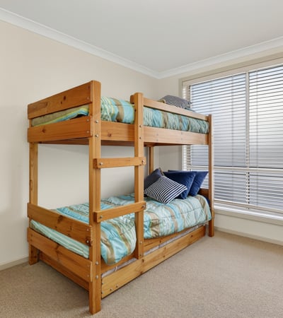 Cozy bedroom featuring a sturdy bunk bed and ample natural light from large windows.