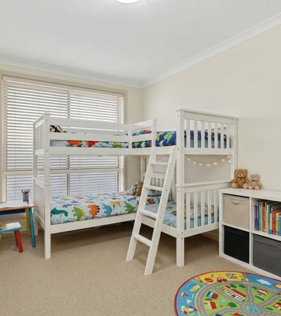 Bright and inviting children's room featuring a bunk bed, playful decor, and ample storage options.