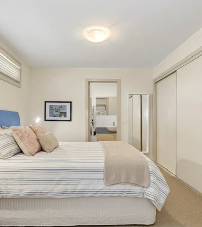 Bright and spacious bedroom featuring ample storage and an inviting atmosphere, perfect for relaxation.