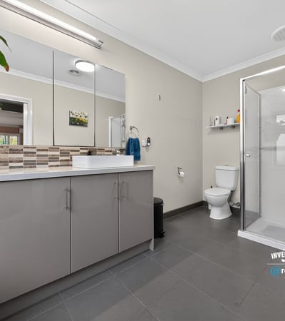 Spacious bathroom featuring modern finishes, a walk-in shower, and ample storage for everyday essentials.