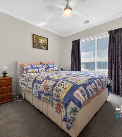 Bright bedroom featuring a spacious layout, large window for natural light, and cozy furnishings.