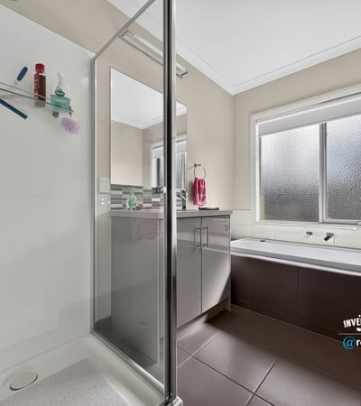 Bright and functional bathroom featuring a glass-enclosed shower and relaxing soaking tub for ultimate convenience.
