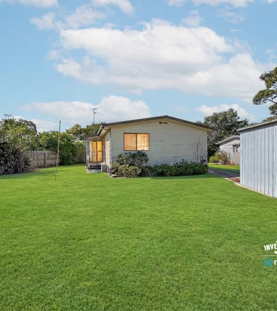 Spacious backyard retreat featuring a well-maintained home, perfect for outdoor activities and family gatherings.