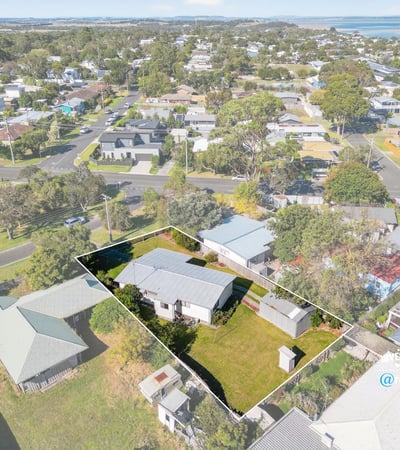 Spacious lot with potential, featuring a cozy home and scenic views near waterfront amenities.