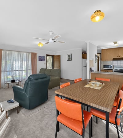 Spacious living area with natural light, featuring a dining space and a functional kitchen layout.