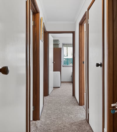 Discover a well-maintained hallway featuring ample natural light and easy access to various rooms.