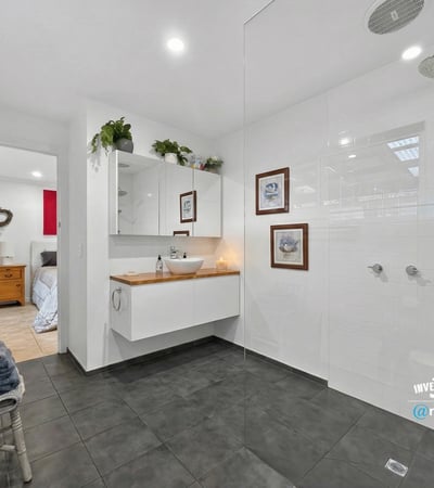 Modern bathroom featuring spacious walk-in shower, dual rainfall showerheads, and sleek cabinetry for organized storage.