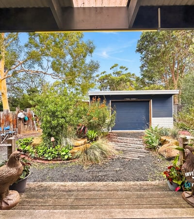 Enjoy a picturesque view of well-maintained gardens and a spacious shed from this outdoor area.