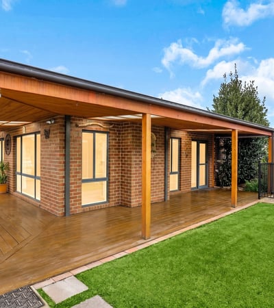 Modern outdoor living area featuring wooden decking, perfect for entertaining in a scenic, landscaped environment.