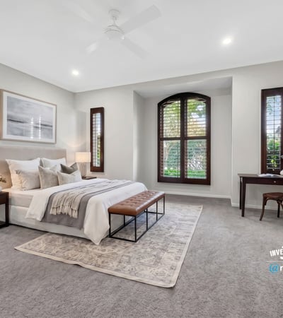 Spacious bedroom featuring large windows, plush carpet, and ample natural light for a cozy atmosphere.