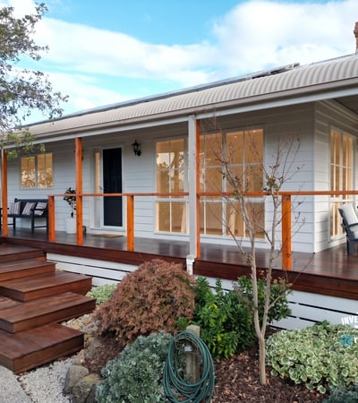 Discover a beautifully designed home featuring a welcoming porch and well-maintained landscaping, perfect for outdoor enjoyment.