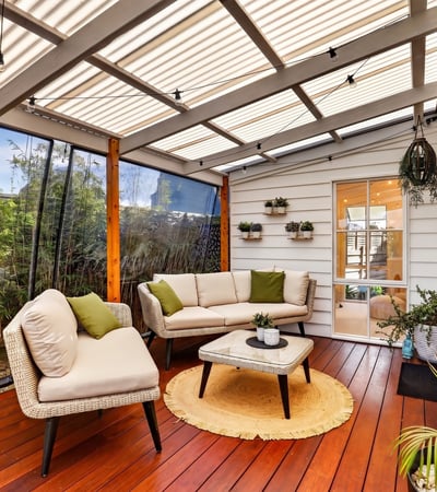 Inviting sunroom featuring comfortable seating, lush greenery, and abundant natural light for relaxed gatherings.