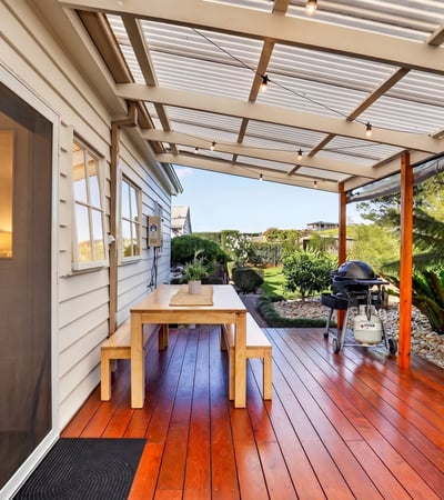 Enjoy outdoor living on this spacious deck, surrounded by lush greenery and perfect for entertaining.