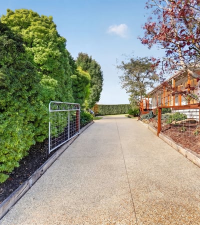Discover this inviting pathway leading to a beautifully landscaped property, ideal for your future home.