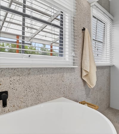 Bright and modern bathroom featuring a spacious tub and large windows for ample natural light.