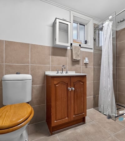 Modern bathroom featuring a sleek shower and functional design with ample storage options.